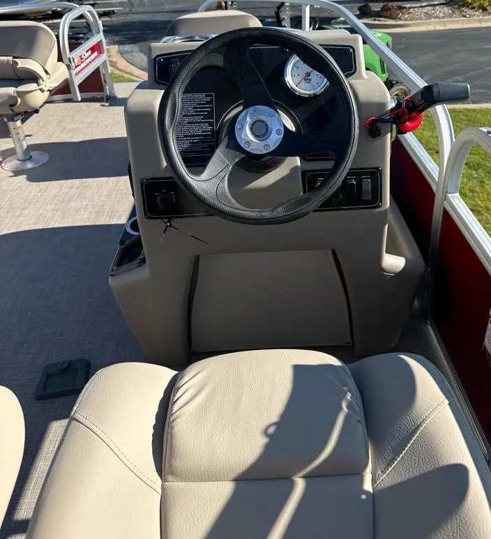 Slide: The Image of 2025 Sun Tracker Bass Buggy 16 XL Select boat interior with steering wheel and seating. - 7