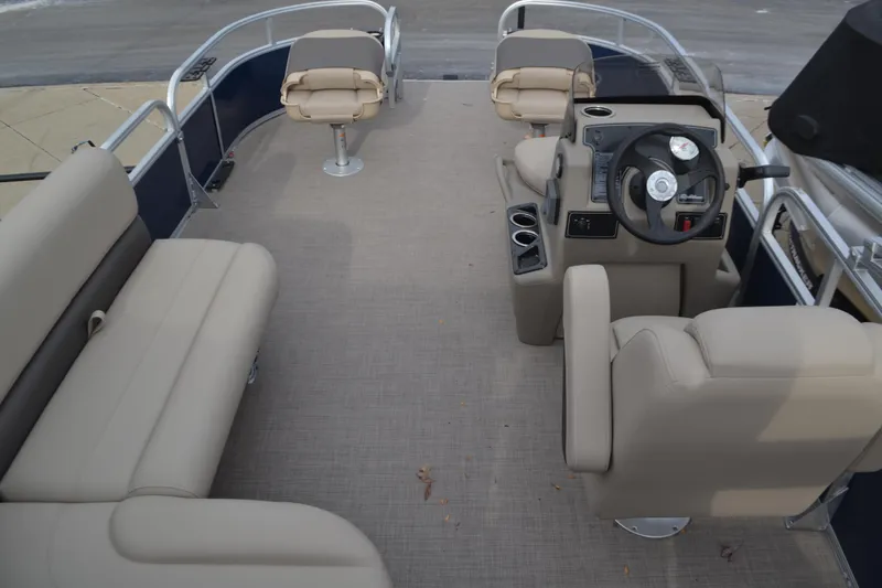 Slide: The Image of 2025 Sun Tracker Bass Buggy 16 XL Select pontoon boat interior with beige seating and steering console. - 4