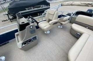 Slide: The Image of 2025 Sun Tracker Bass Buggy 18 DLX pontoon boat interior with beige seating and steering console. - 19