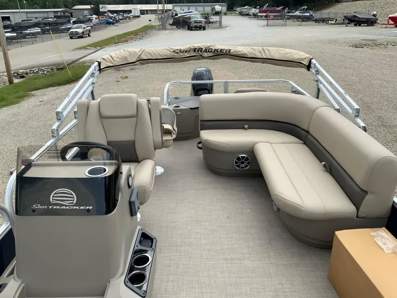Slide: The Image of 2025 Sun Tracker Bass Buggy 18 DLX pontoon boat with beige seating and helm. - 5