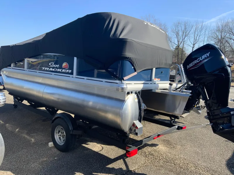 Slide: The Image of 2025 Sun Tracker Bass Buggy 18 DLX pontoon boat with Mercury outboard motor, covered and on trailer. - 9