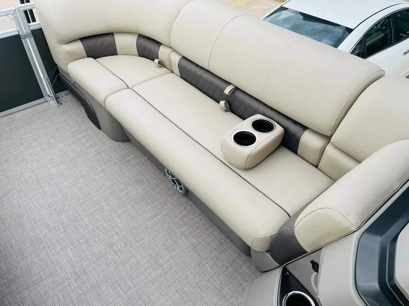 Slide: The Image of 2025 Sun Tracker Party Barge 20 DLX interior with beige seating and cup holders. - 15