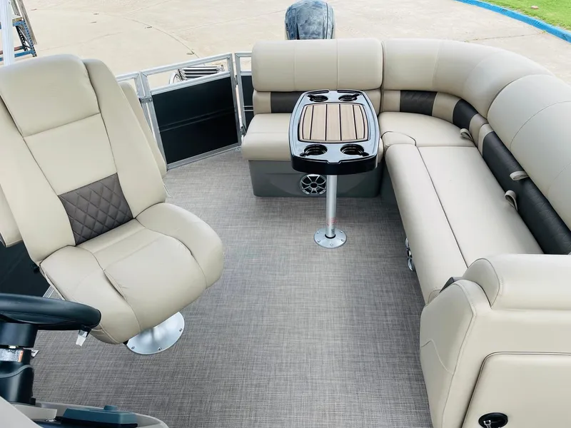 Slide: The Image of 2025 Sun Tracker Party Barge 20 DLX interior with beige seating and table. - 24
