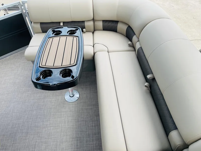 Slide: The Image of 2025 Sun Tracker Party Barge 20 DLX interior with beige seating and table. - 26