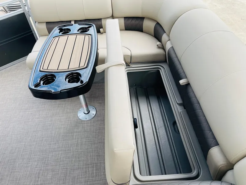 Slide: The Image of 2025 Sun Tracker Party Barge 20 DLX interior with seating, table, and storage compartment. - 28