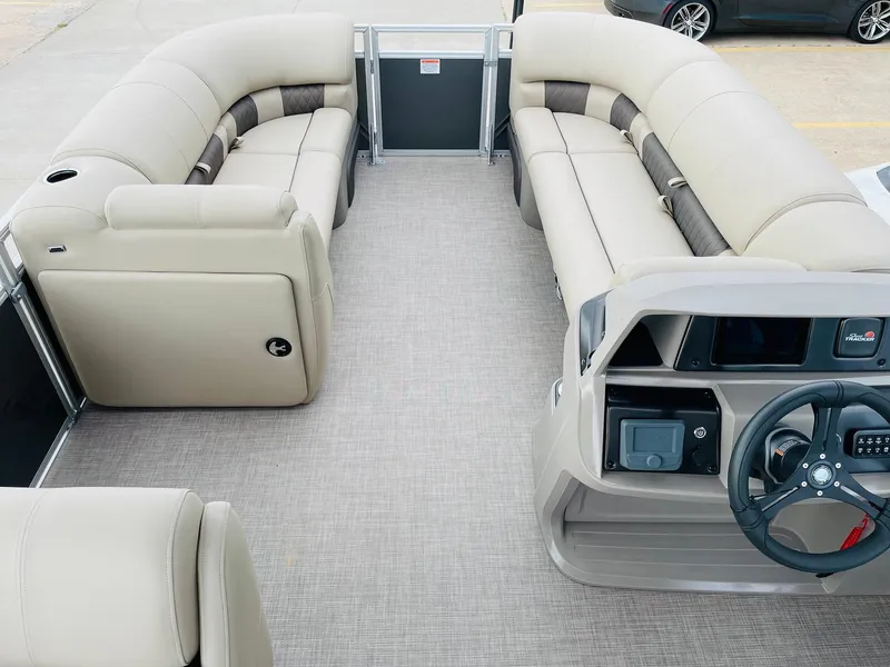Slide: The Image of 2025 Sun Tracker Party Barge 20 DLX interior with beige seating and steering console. - 8