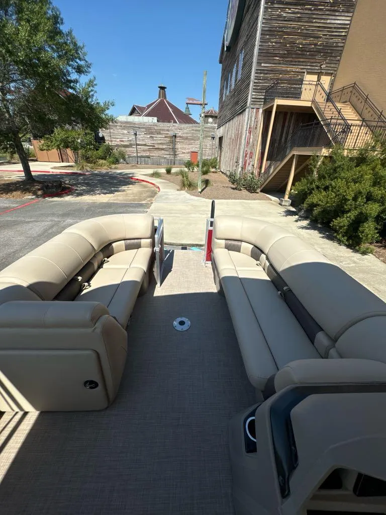 Slide: The Image of 2025 Sun Tracker Party Barge 22 DLX interior with beige seating, outdoor setting. - 4