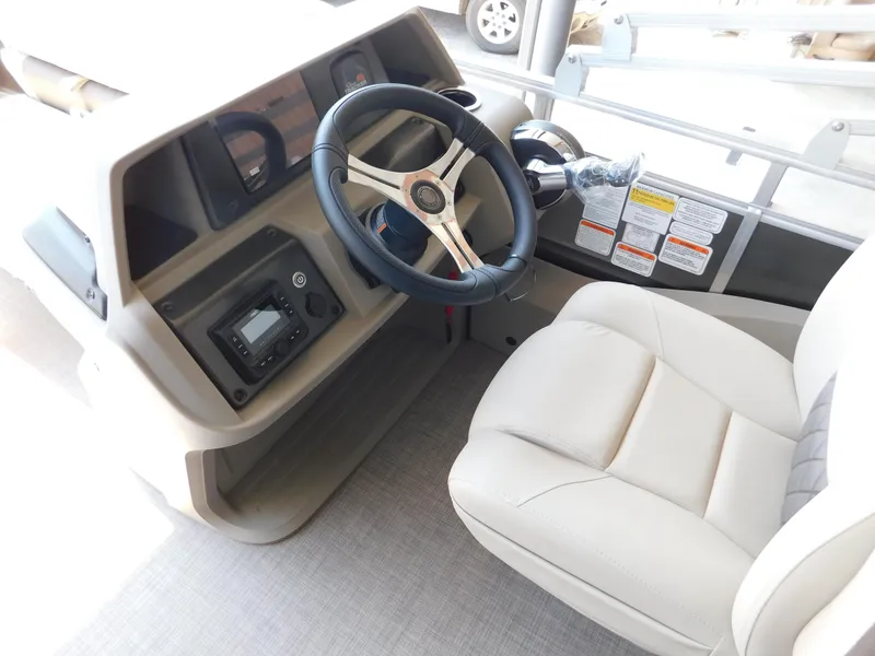 Slide: The Image of 2025 Sun Tracker Fishin' Barge 22 DLX helm with steering wheel and controls. - 12