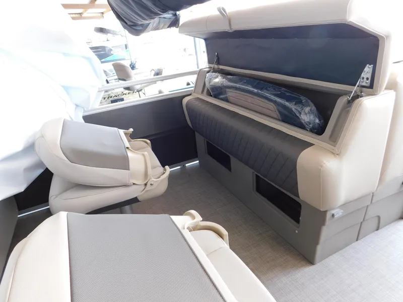 Slide: The Image of 2025 Sun Tracker Fishin' Barge 22 DLX interior seating with storage compartment open. - 18