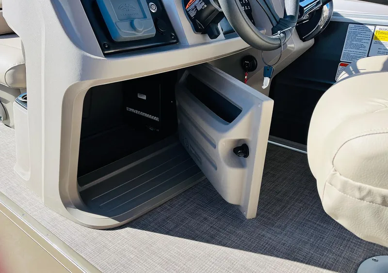 Slide: The Image of 2025 Sun Tracker Party Barge 22 RF XP3 storage compartment with open door, showcasing interior space. - 34
