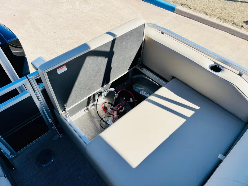 Slide: The Image of 2025 Sun Tracker Party Barge 22 RF XP3 storage compartment with open seat and battery cables. - 46