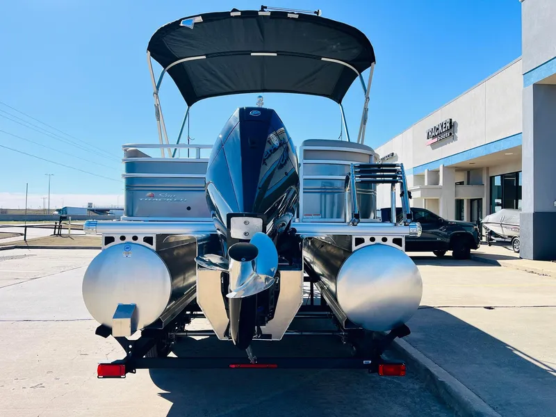 Slide: The Image of 2025 Sun Tracker Party Barge 22 RF XP3 pontoon boat with canopy and motor, parked outside. - 6