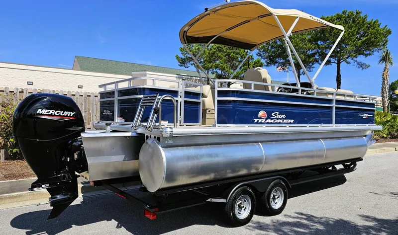 Slide: The Image of 2025 Sun Tracker Fishin' Barge 22 XP3 pontoon boat with Mercury engine on trailer. - 2