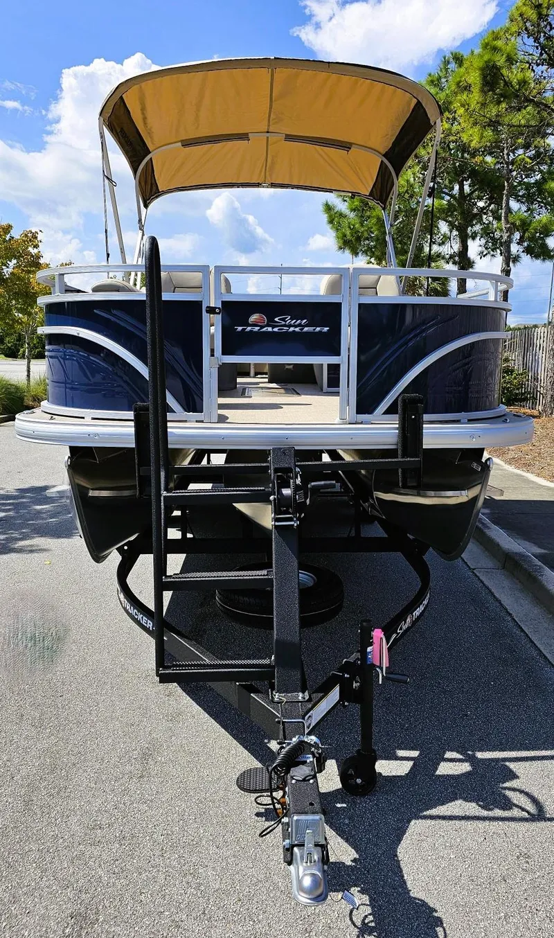Slide: The Image of 2025 Sun Tracker Fishin' Barge 22 XP3 pontoon boat on trailer, parked outdoors. - 6