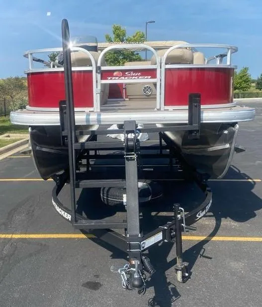 Slide: The Image of 2025 Sun Tracker Bass Buggy 16 XL Select pontoon boat on trailer in parking lot. - 5