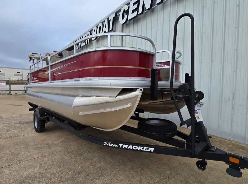 Slide: The Image of 2025 Sun Tracker Bass Buggy 18 DLX pontoon boat on trailer, red and silver design. - 2