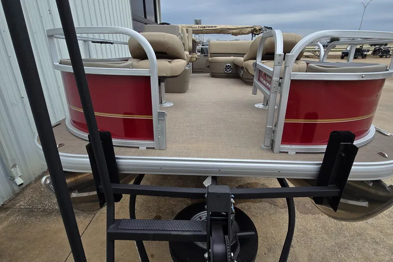 Slide: The Image of 2025 Sun Tracker Bass Buggy 18 DLX pontoon boat with red exterior and beige seating. - 4