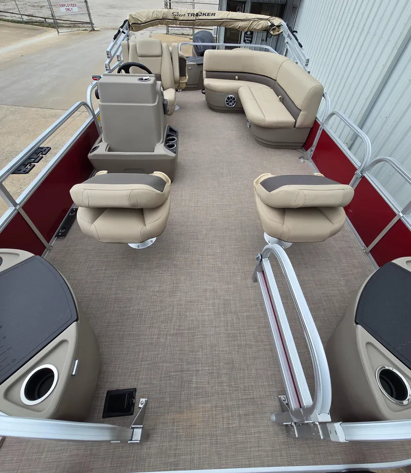 Slide: The Image of 2025 Sun Tracker Bass Buggy 18 DLX pontoon boat interior with beige seating and red accents. - 9