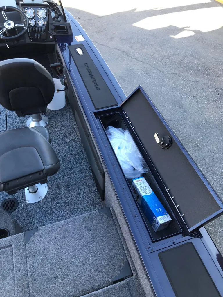 Slide: The Image of 2025 Tracker Targa V-19 Combo boat interior with storage compartment open. - 11