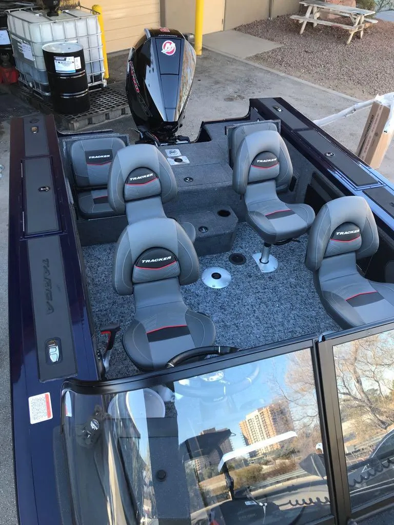 Slide: The Image of 2025 Tracker Targa V-19 Combo boat with seating and motor, docked outdoors. - 12