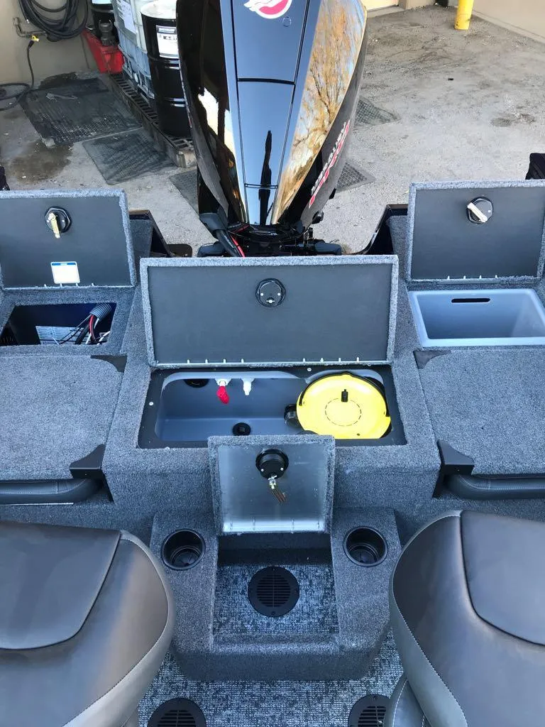 Slide: The Image of 2025 Tracker Targa V-19 Combo boat interior with storage compartments and seating. - 14