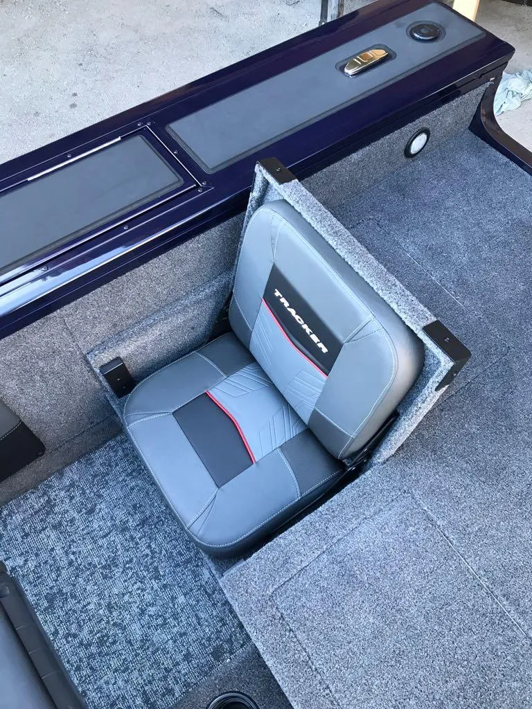 Slide: The Image of 2025 Tracker Targa V-19 Combo boat seat with gray upholstery and red accents. - 16