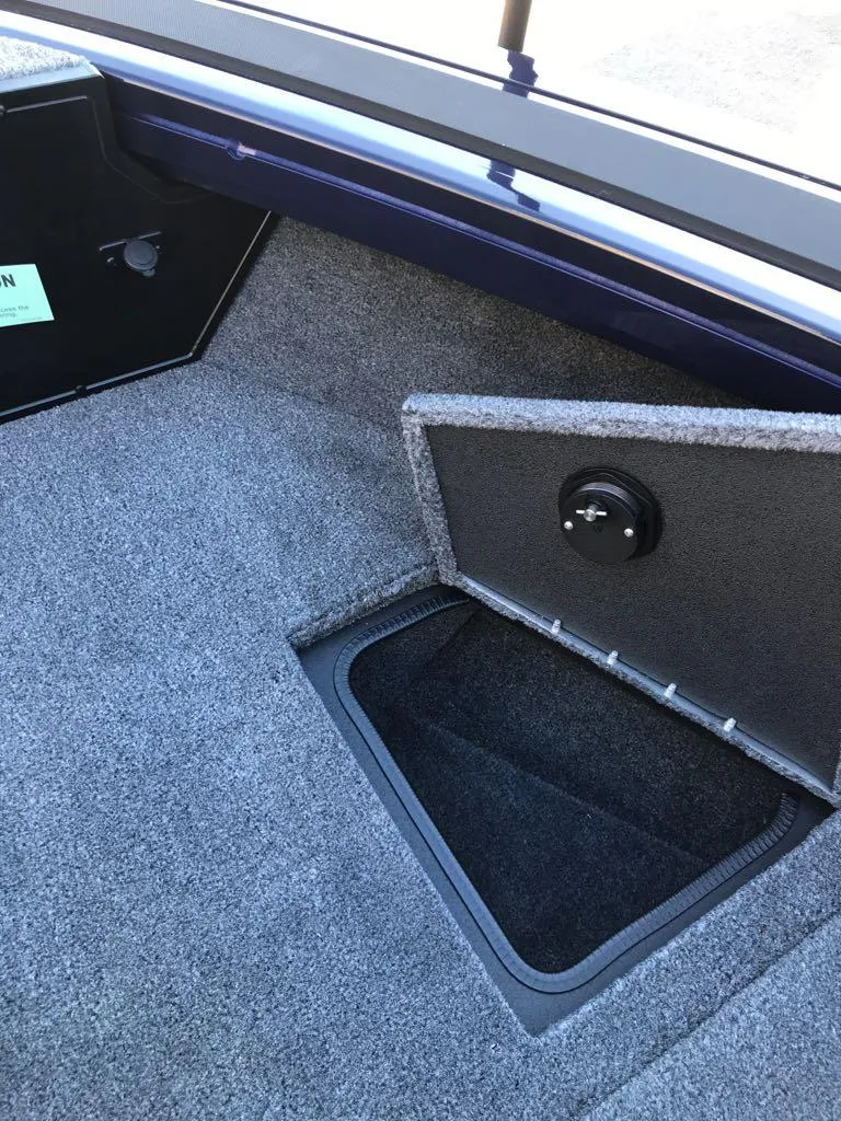 Slide: The Image of 2025 Tracker Targa V-19 Combo boat storage compartment with carpeted interior. - 20