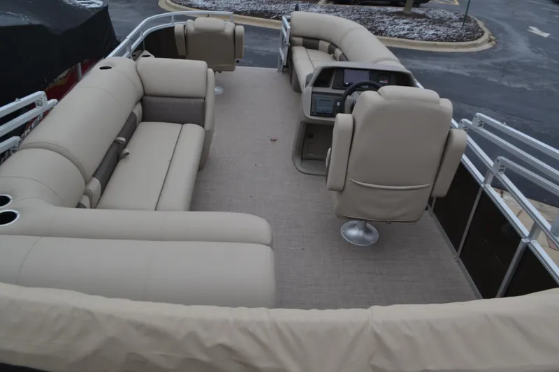 Slide: The Image of 2025 Sun Tracker SportFish 20 DLX pontoon boat interior with beige seating and helm. - 3