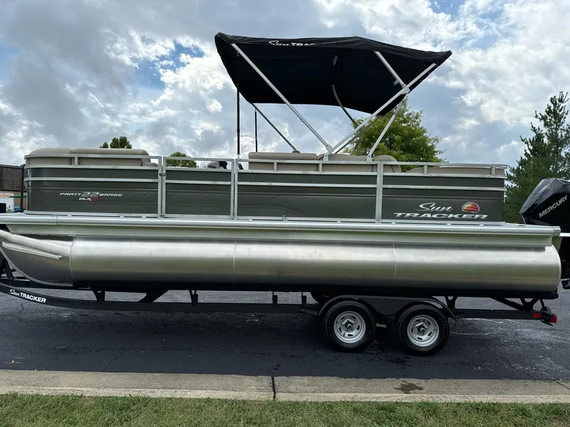 The Image of 2025 Sun Tracker Party Barge 22 RF XP3 pontoon boat on trailer, parked outdoors. - 0