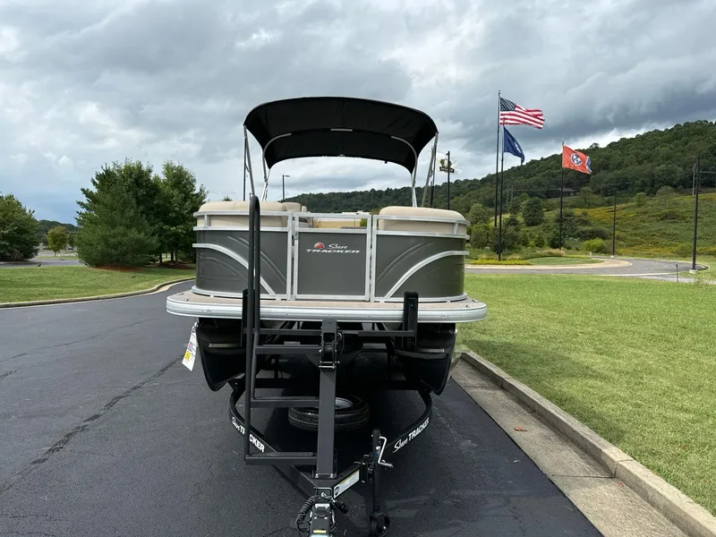 Slide: The Image of 2025 Sun Tracker Party Barge 22 RF XP3 on trailer, flags in background. - 4