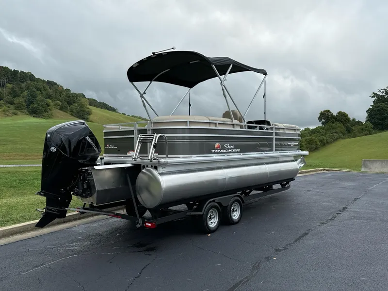 Slide: The Image of 2025 Sun Tracker Party Barge 22 RF XP3 pontoon boat on trailer, parked outdoors. - 5