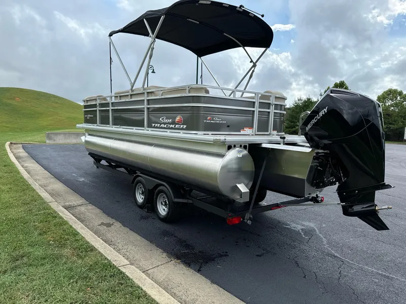 Slide: The Image of 2025 Sun Tracker Party Barge 22 RF XP3 pontoon boat on trailer, parked outdoors. - 6
