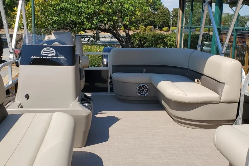 Slide: The Image of 2025 Sun Tracker Party Barge 16 DLX interior with beige seating and helm. - 46