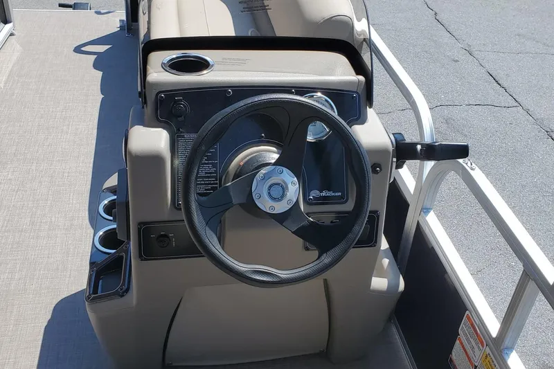 Slide: The Image of 2025 Sun Tracker Party Barge 16 DLX steering console with cup holders and controls. - 47