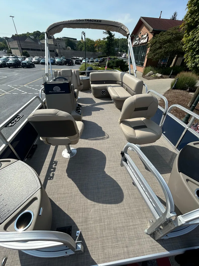 Slide: The Image of 2025 Sun Tracker Bass Buggy 18 DLX pontoon boat with spacious seating and modern design. - 2