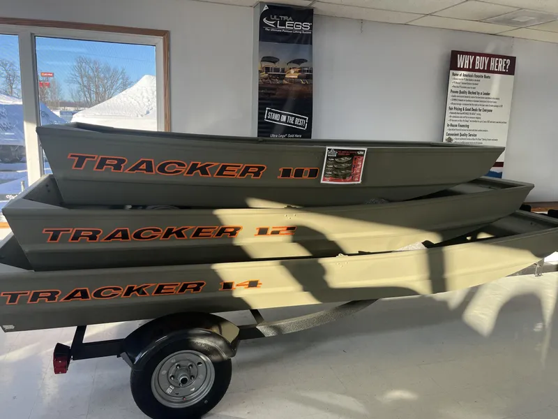 The Image of 2025 Tracker Grizzly 1036 Utility boats stacked on a trailer in a showroom. - 0