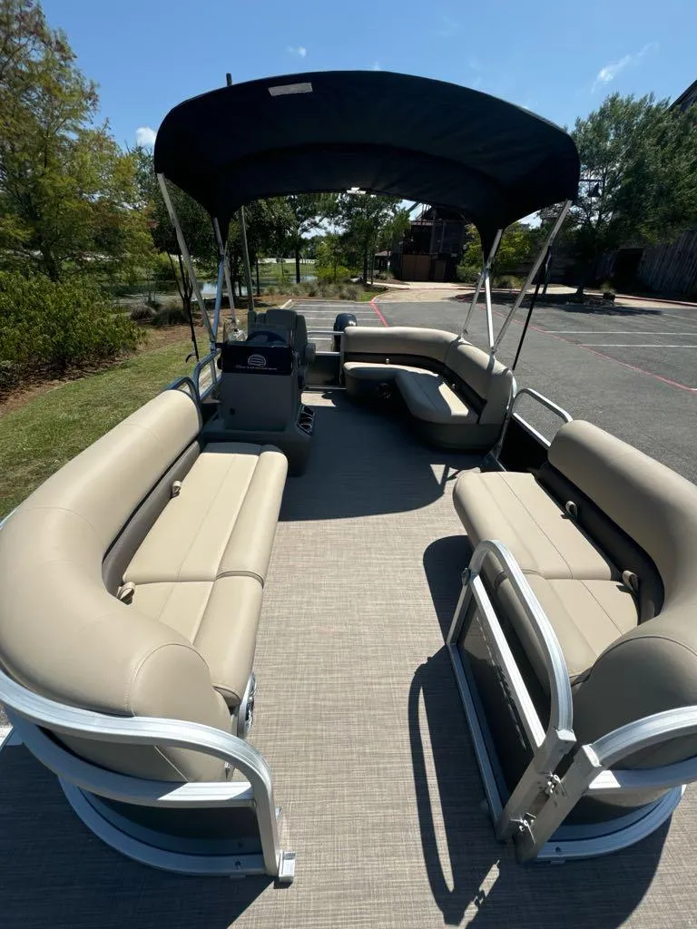 Slide: The Image of 2025 Sun Tracker Party Barge 16 DLX pontoon boat with beige seating and canopy. - 4