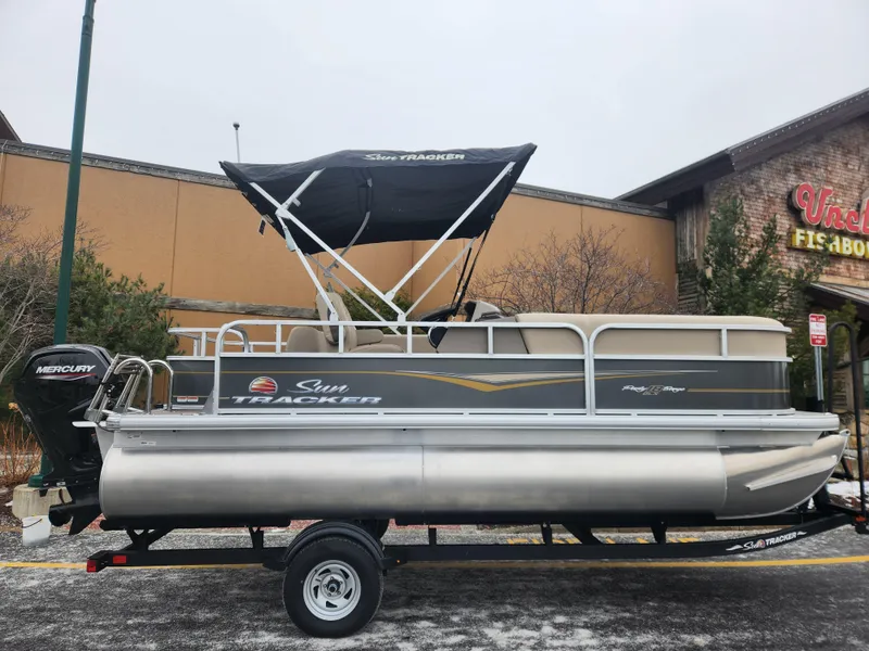 The Image of 2025 Sun Tracker Party Barge 18 DLX pontoon boat on trailer, outdoor display. - 0