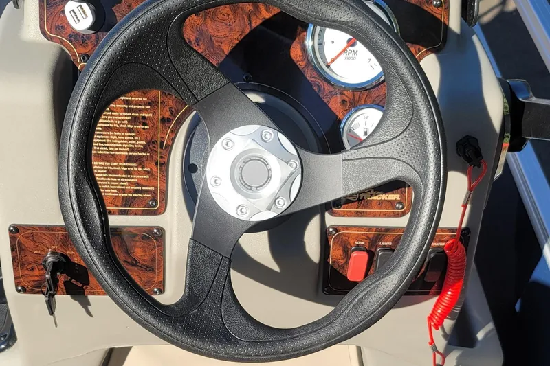 Slide: The Image of Steering wheel of 2025 Sun Tracker Bass Buggy 18 DLX with dashboard controls. - 6