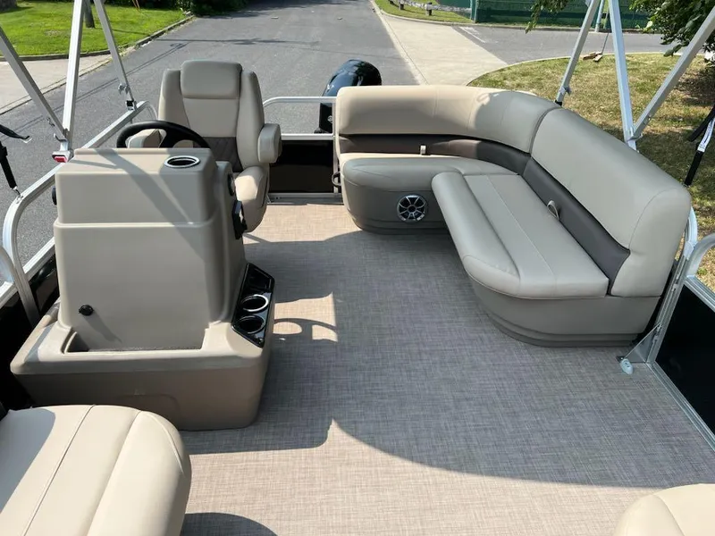 Slide: The Image of 2025 Sun Tracker Party Barge 16 DLX interior with beige seating and steering console. - 11