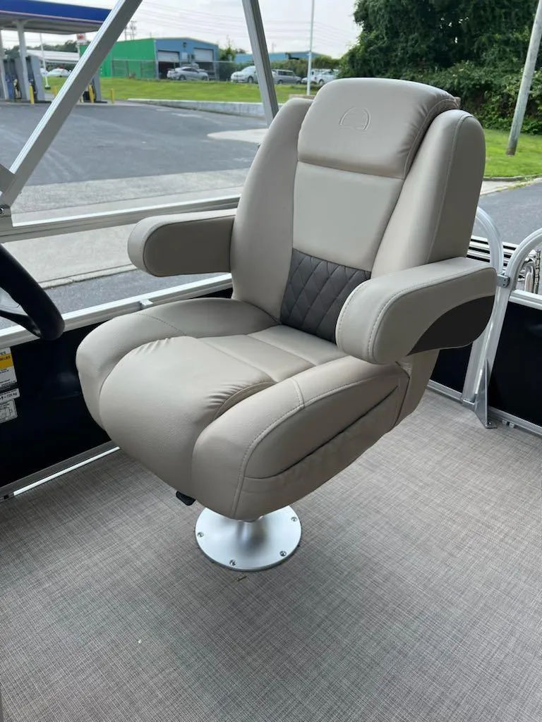 Slide: The Image of 2025 Sun Tracker Party Barge 16 DLX captain's chair, beige upholstery, outdoor setting. - 12