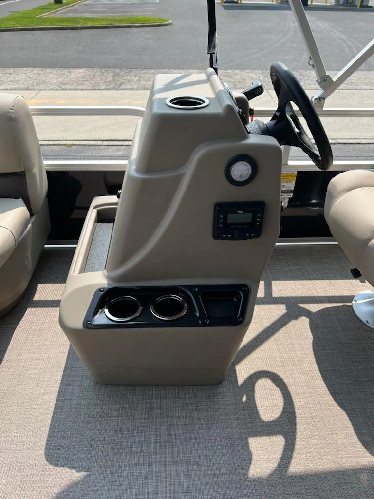Slide: The Image of 2025 Sun Tracker Party Barge 16 DLX helm with cup holders and steering wheel. - 8