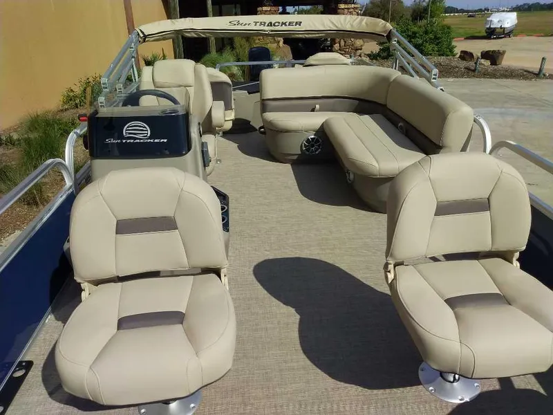 Slide: The Image of 2025 Sun Tracker Bass Buggy 18 DLX pontoon boat with beige seating and spacious deck. - 2