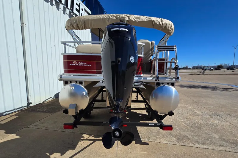 Slide: The Image of 2025 Sun Tracker Party Barge 18 DLX pontoon boat, rear view with motor and canopy. - 3