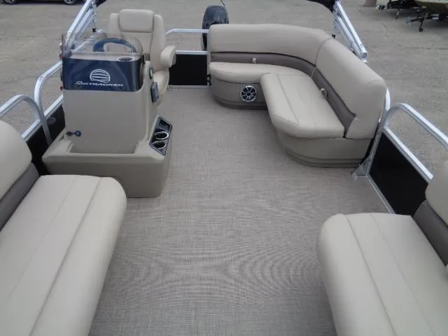 Slide: The Image of 2025 Sun Tracker Party Barge 16 DLX interior with beige seating and steering console. - 47