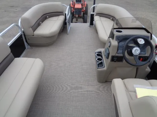 Slide: The Image of 2025 Sun Tracker Party Barge 16 DLX interior with beige seating and steering console. - 48