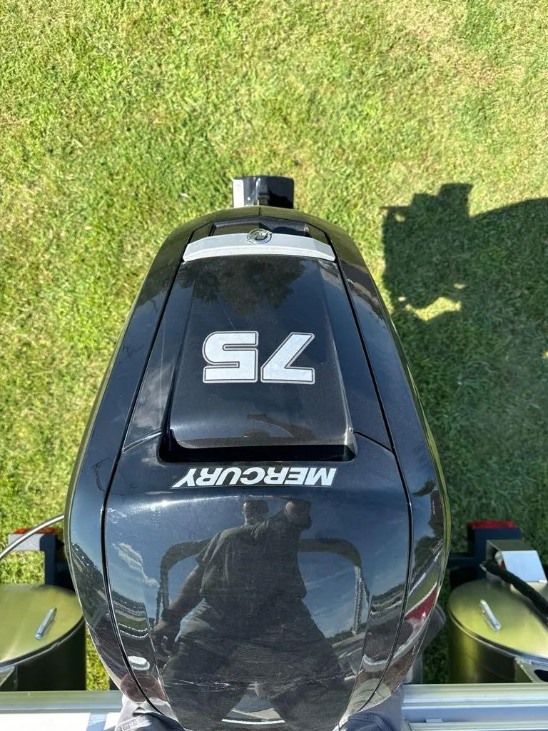 Slide: The Image of Mercury 75 outboard motor on 2025 Sun Tracker Bass Buggy 18 DLX, grassy background. - 3