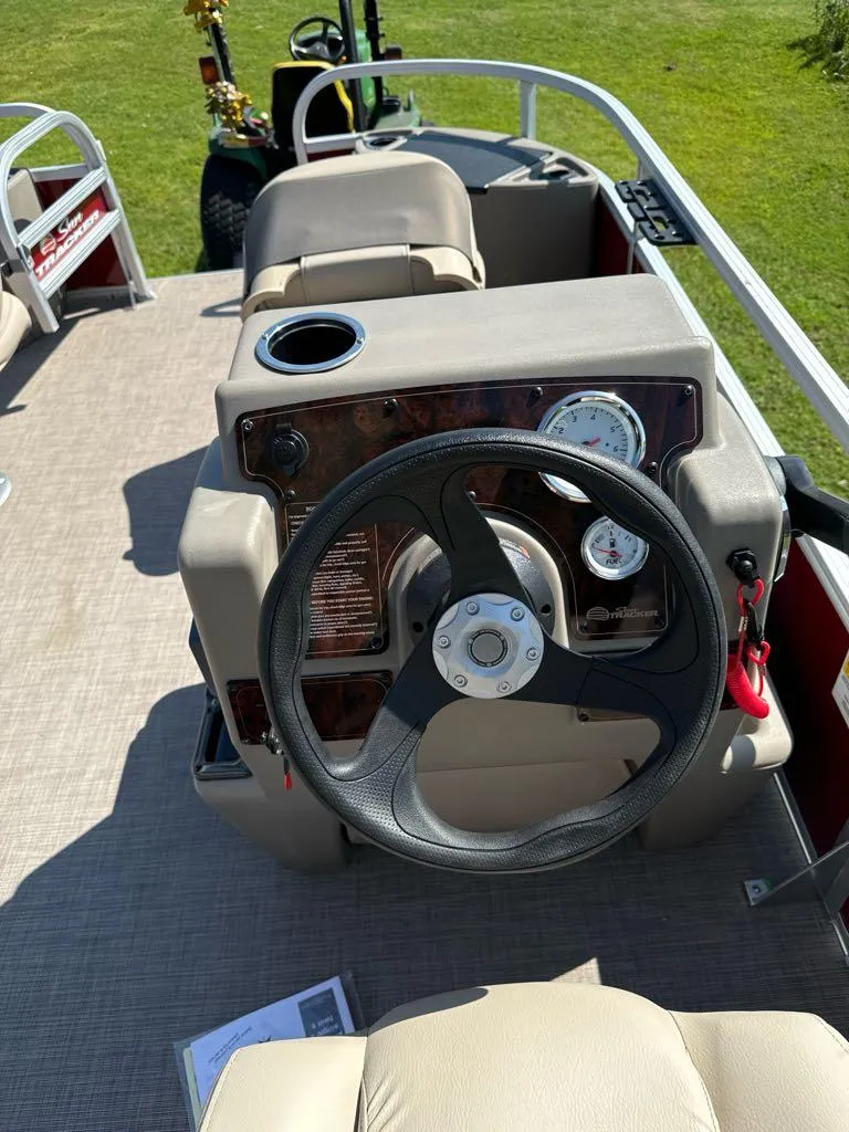 Slide: The Image of 2025 Sun Tracker Bass Buggy 18 DLX steering console with gauges and cup holder. - 4