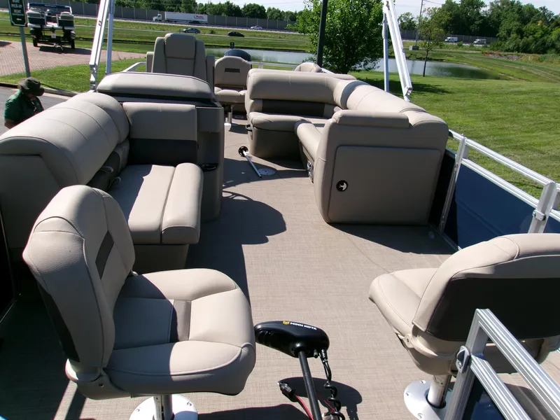 Slide: The Image of 2025 Sun Tracker Fishin' Barge 22 DLX interior with beige seating and open deck layout. - 4