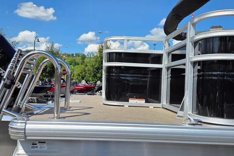 Slide: The Image of 2025 Sun Tracker Sportfish 24 XP3 pontoon boat with sleek railing and ladder under a clear sky. - 3